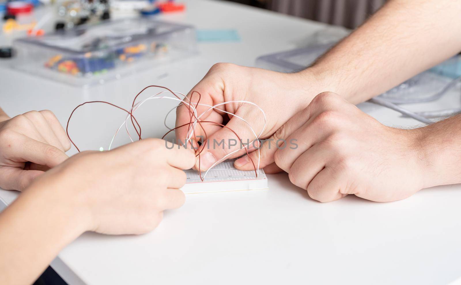 boy hands working with LED lights on experimental board for science project