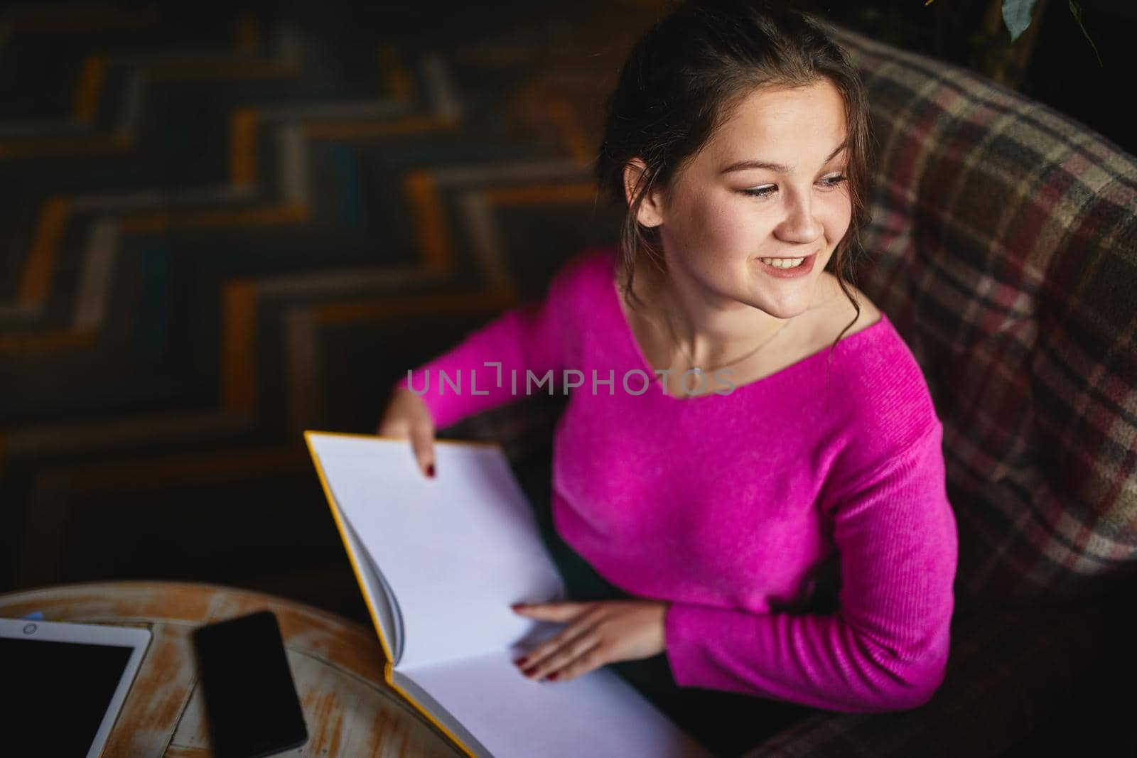 Happy young lady resting in cozy cafe by monakoartstudio