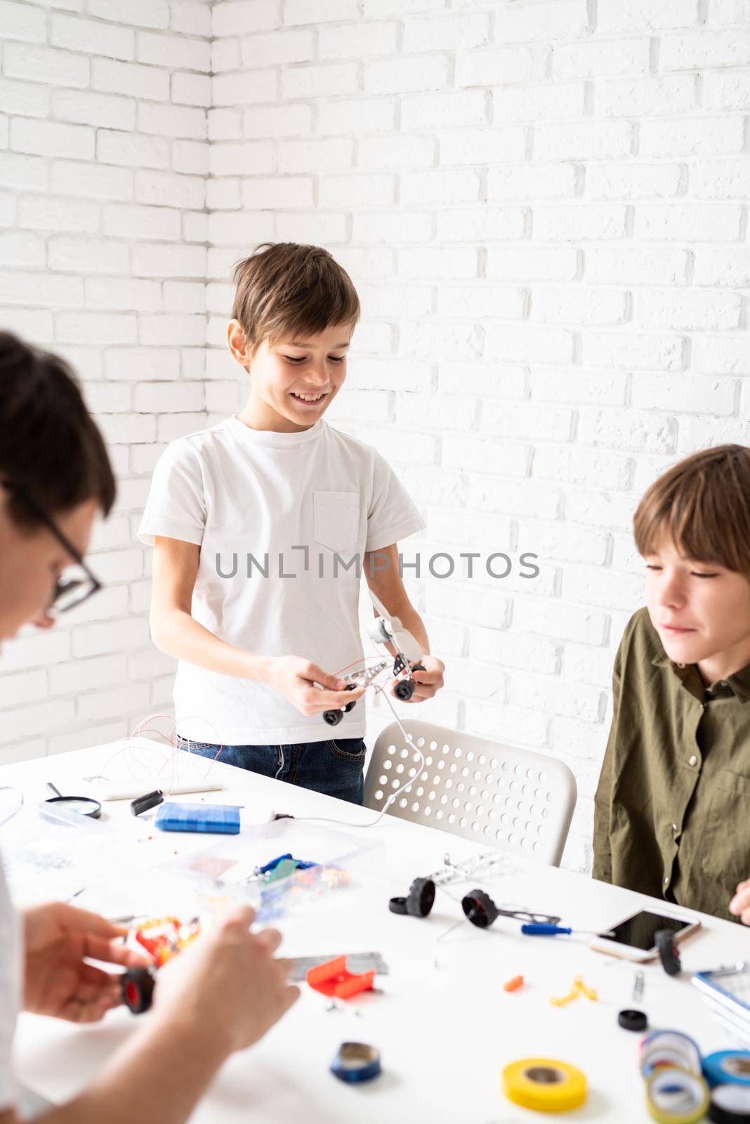 Young boys and having fun constructing robot cars together at the workshop