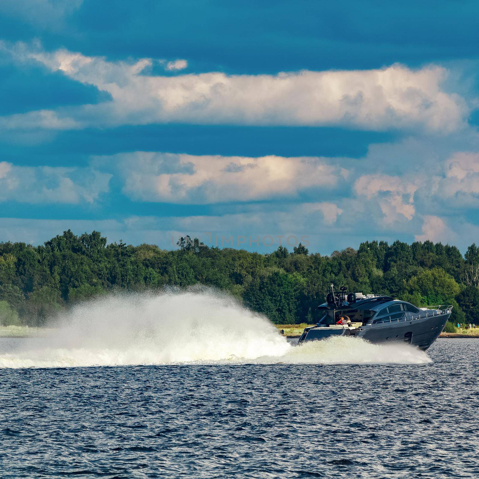 Grey speedboat moving fast by the river in Latvia. Water sport