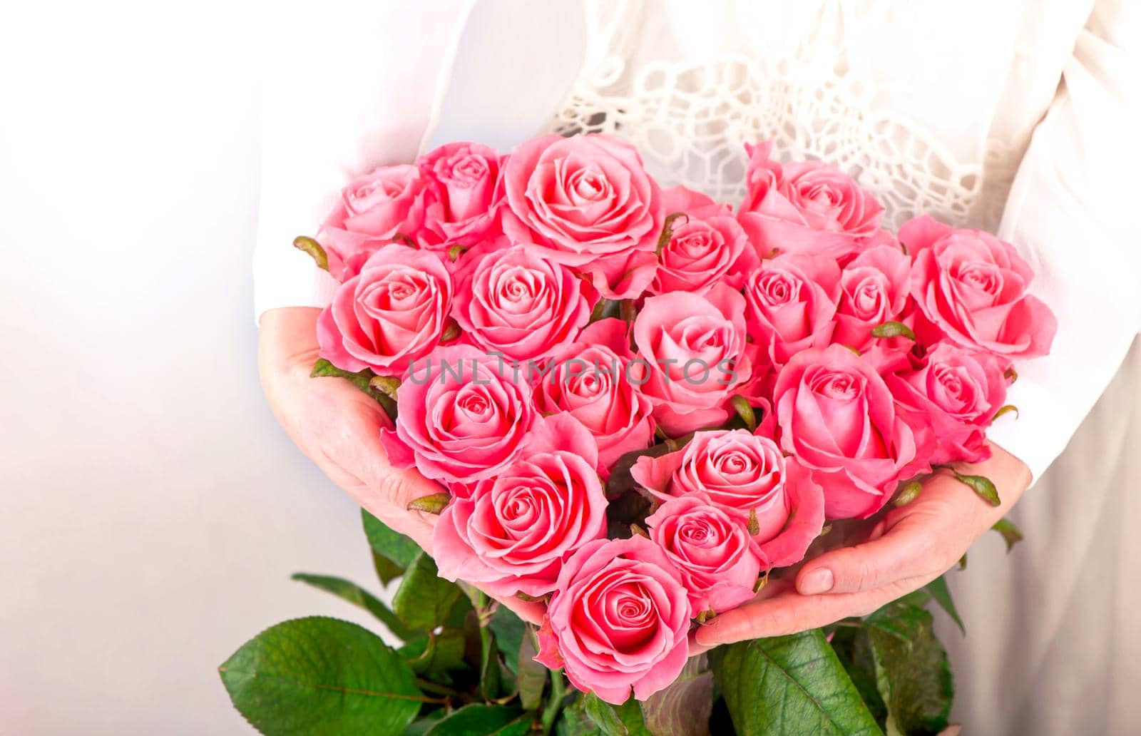 bouquet of pink roses in the shape of a heart in female hands