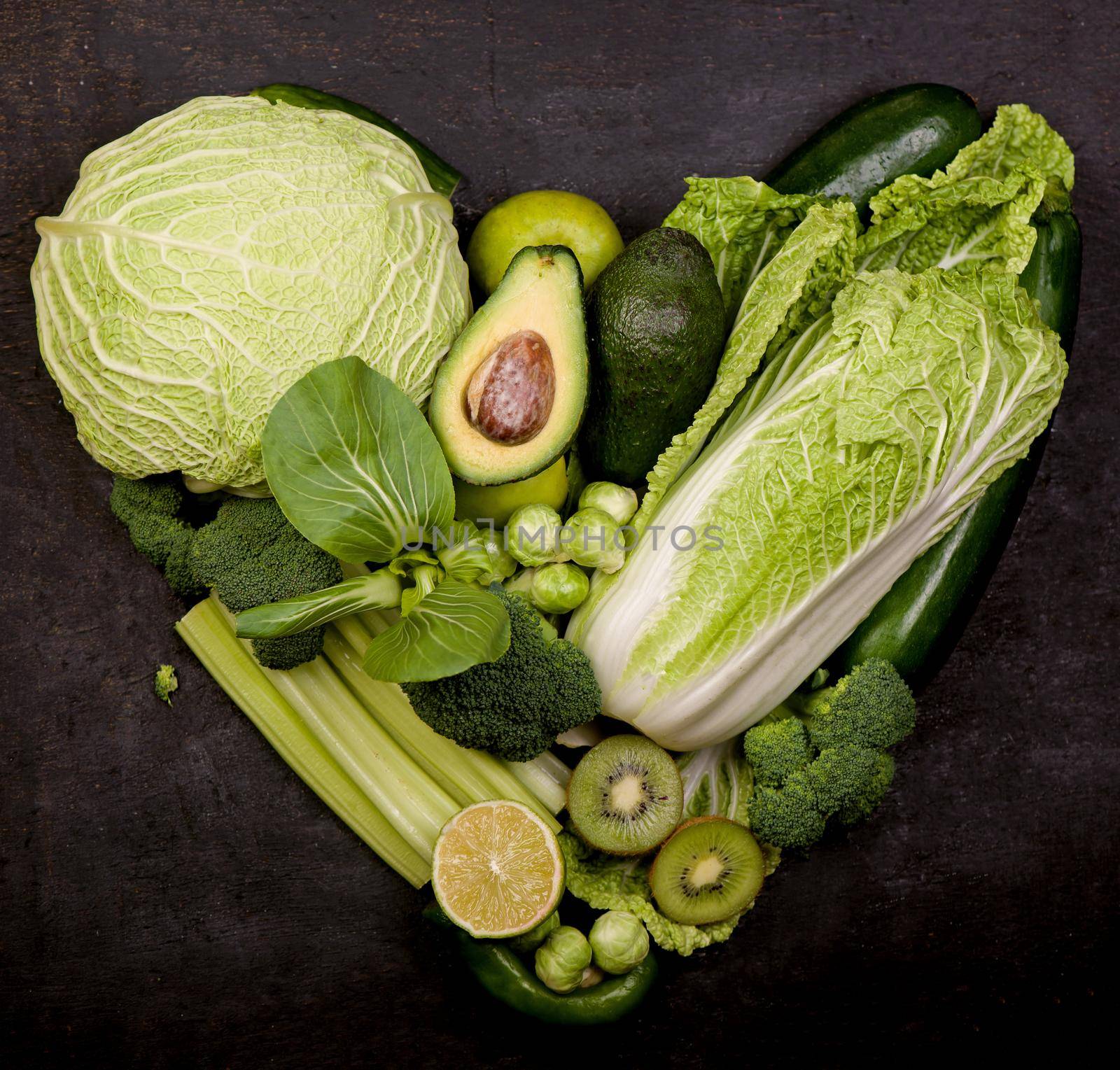 still life with cabbage on a white background in the form of a green heart