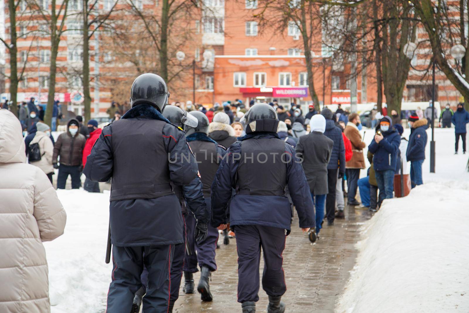 TULA, RUSSIA - JANUARY 23, 2021: Public mass meeting in support of Alexei Navalny, group of police officers going to arrest protesters. View from back.