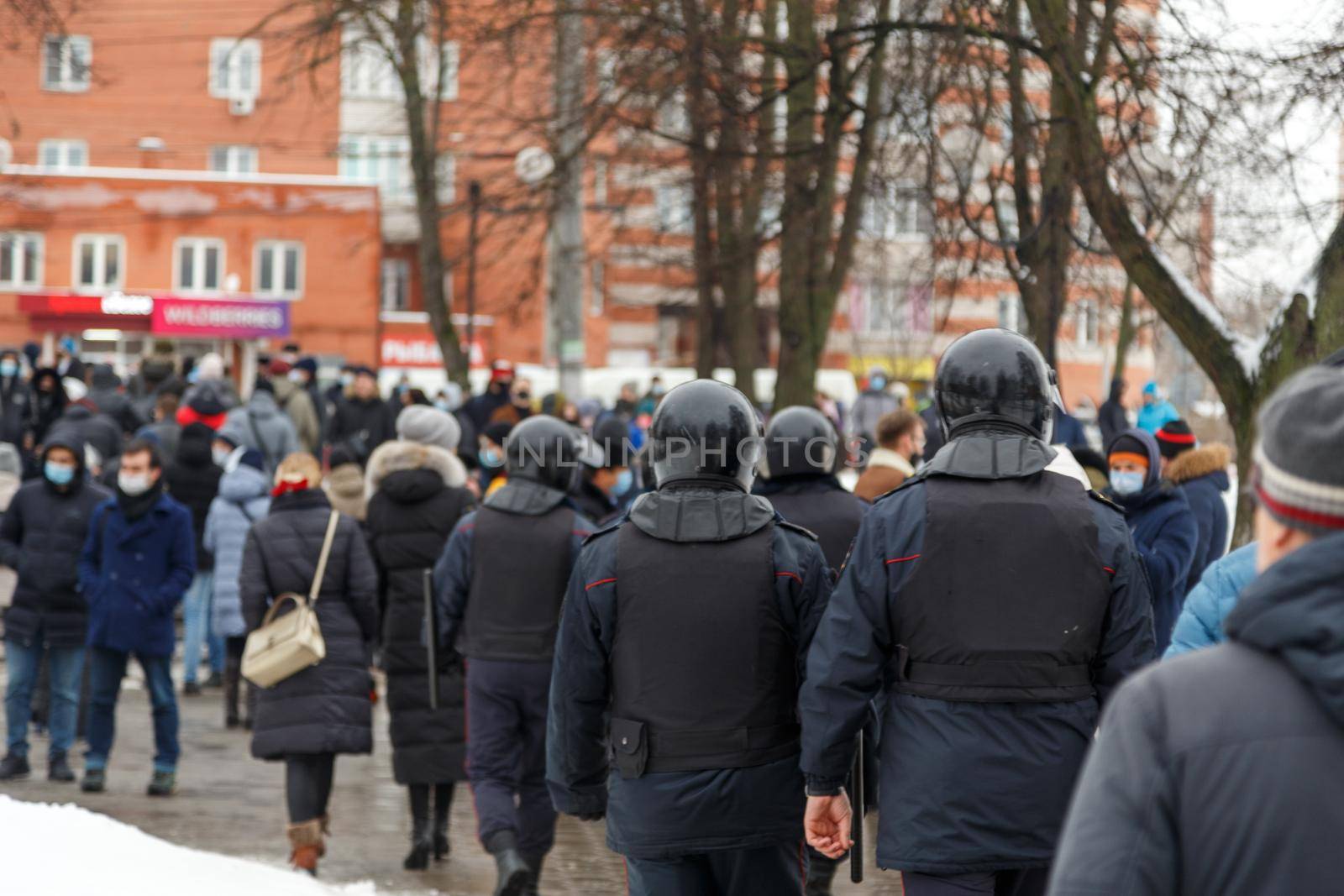 TULA, RUSSIA - JANUARY 23, 2021: Public mass meeting in support of Alexei Navalny, group of police officers going to arrest protesters. View from back.