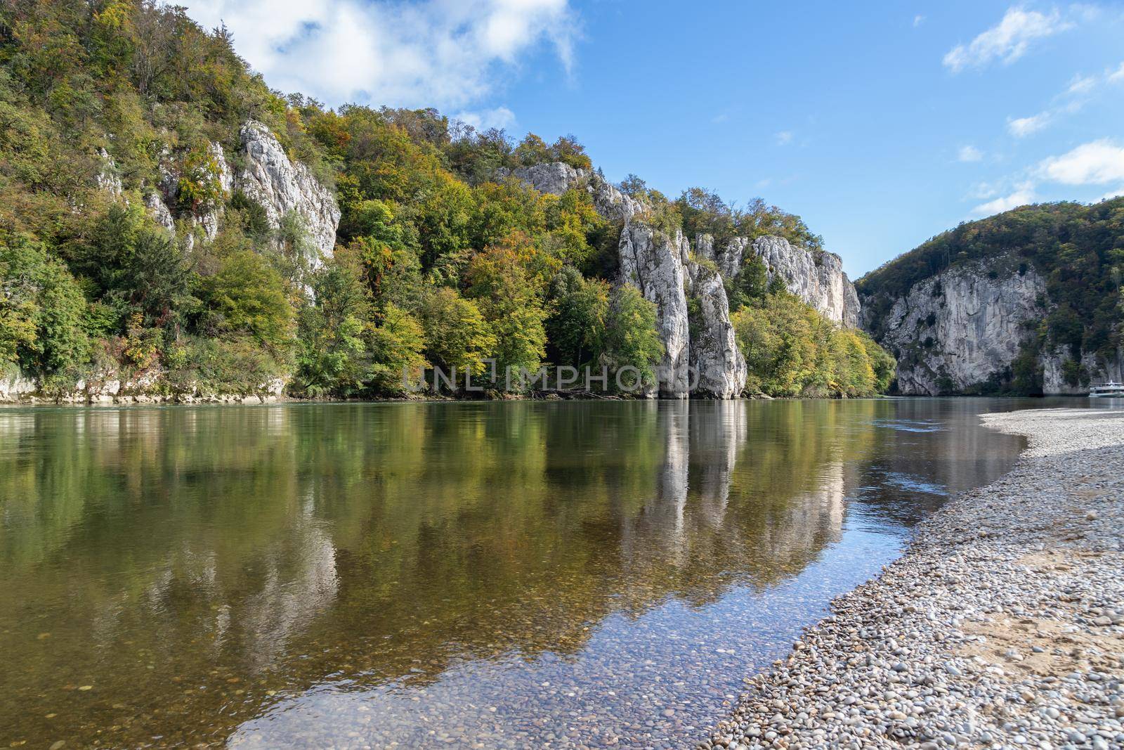 Danube valley at Danube breakthrough near Kelheim, Bavaria, Germany in autumn with gravel bank  and water reflections of limestone formations 