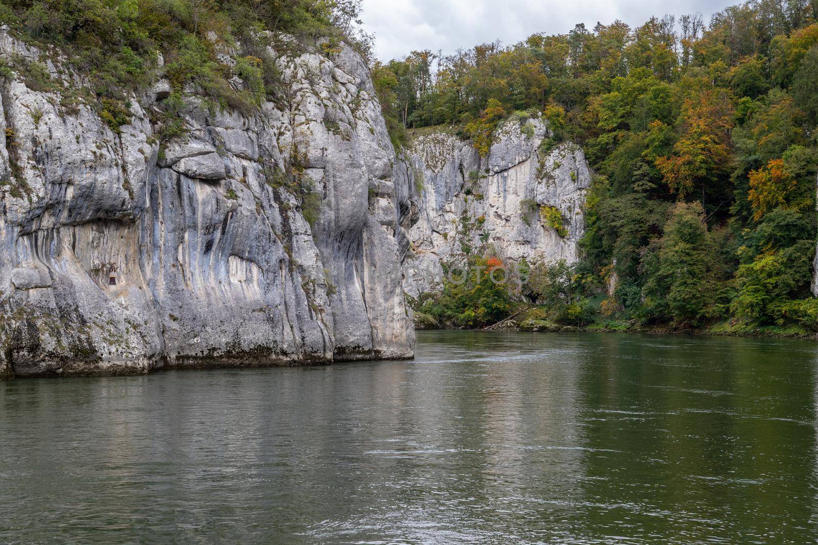 Danube river at Danube breakthrough near Kelheim, Bavaria, Germany in autumn with limestone rock formations and plants with colorful leaves