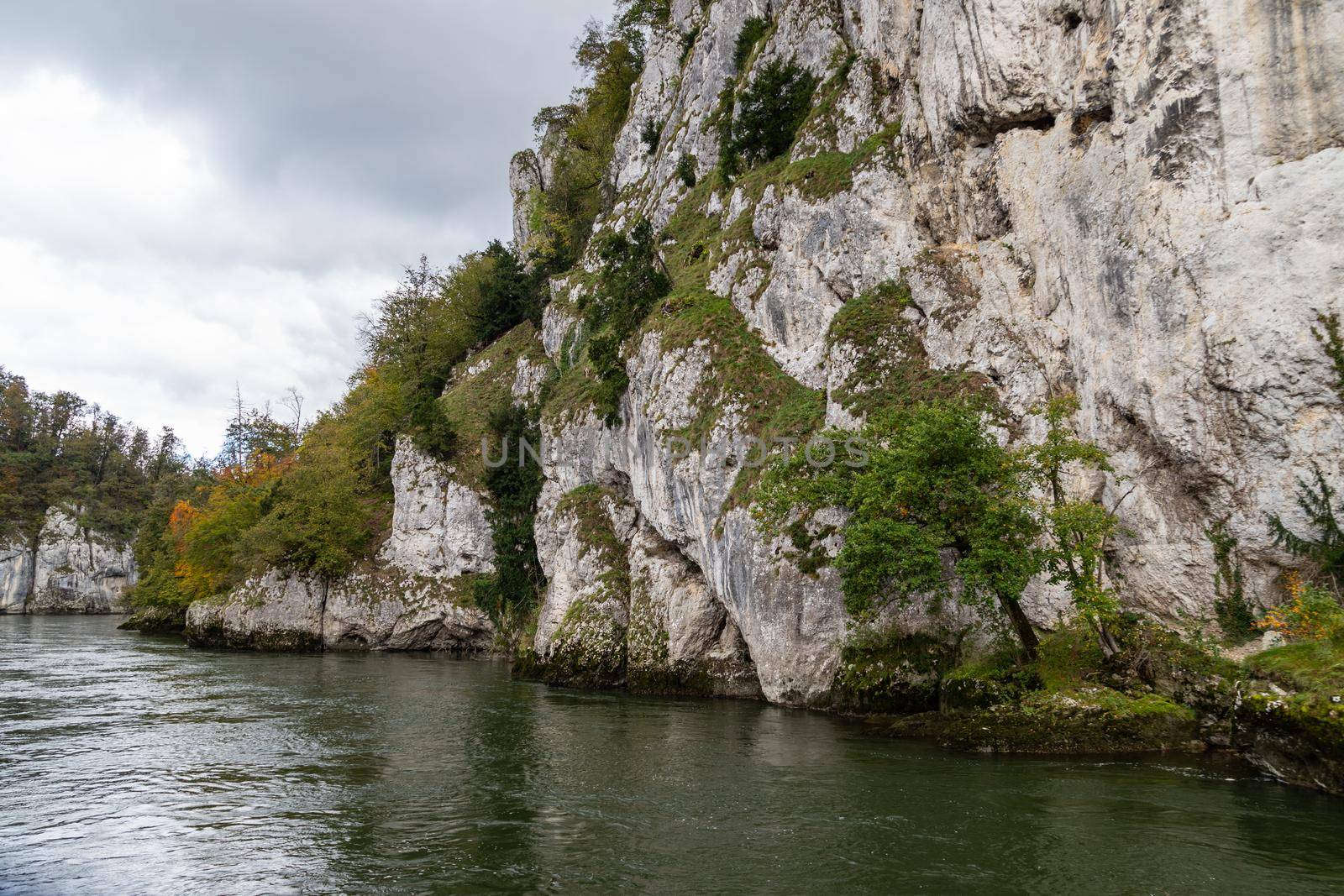 Danube river at Danube breakthrough near Kelheim, Bavaria, Germany in autumn with limestone rock formations and plants with colorful leaves