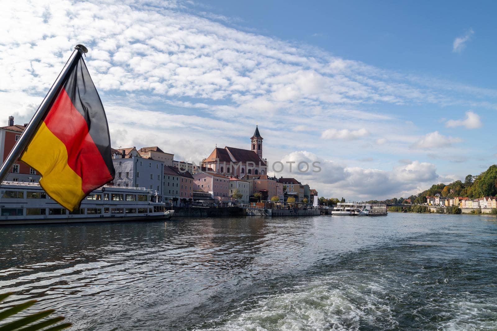 View at Passau during a ship excursion in autumn with the german flag in foreground