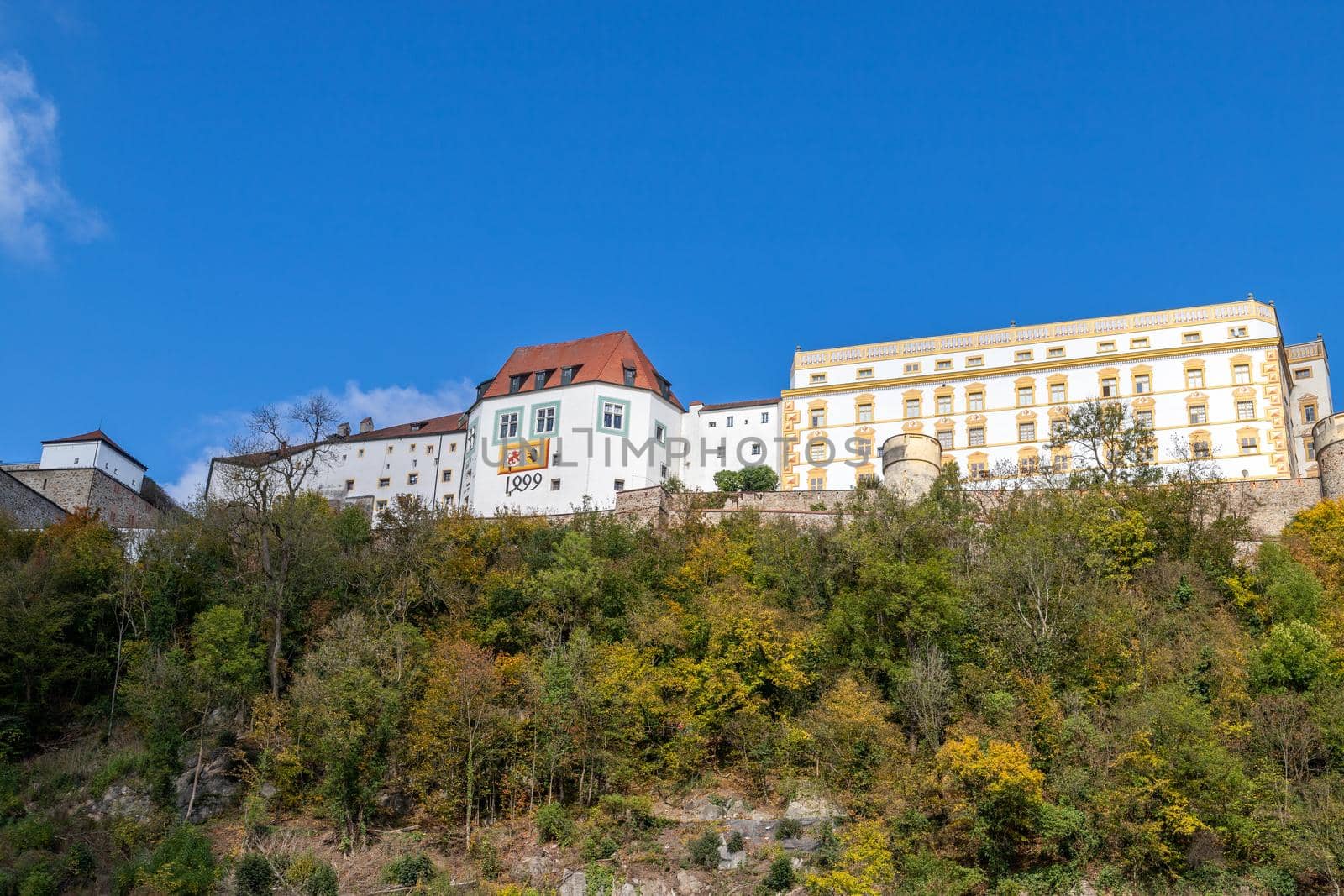 View at fortress Veste Oberhaus in Passau during a ship excursion in autumn with colorfull trees