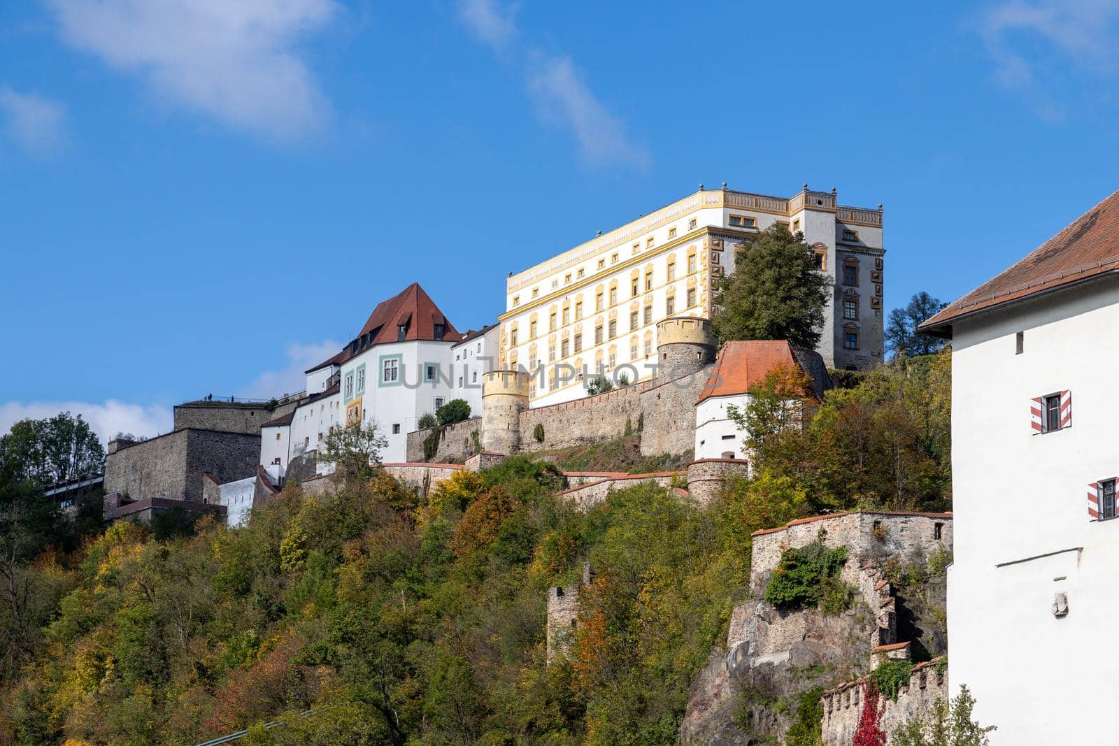 View at fortress Veste Oberhaus in Passau during a ship excursion in autumn with colorfull trees