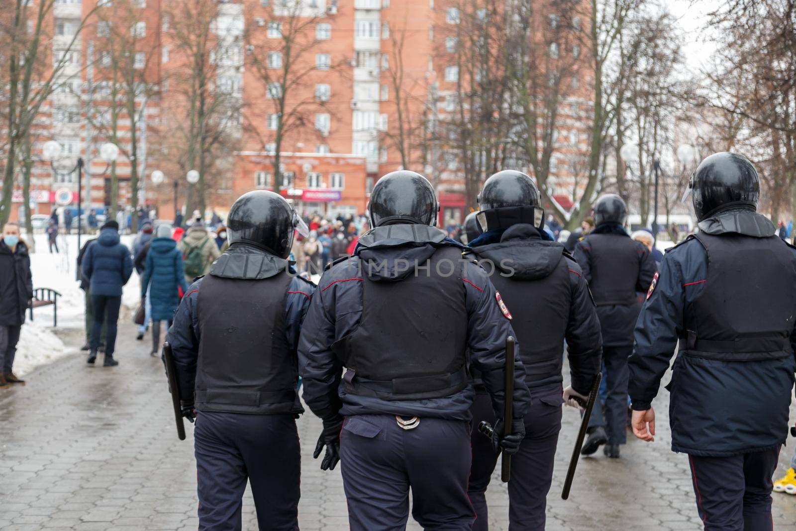 TULA, RUSSIA - JANUARY 23, 2021: Public mass meeting in support of Alexei Navalny, group of police officers going to arrest protesters. View from back.