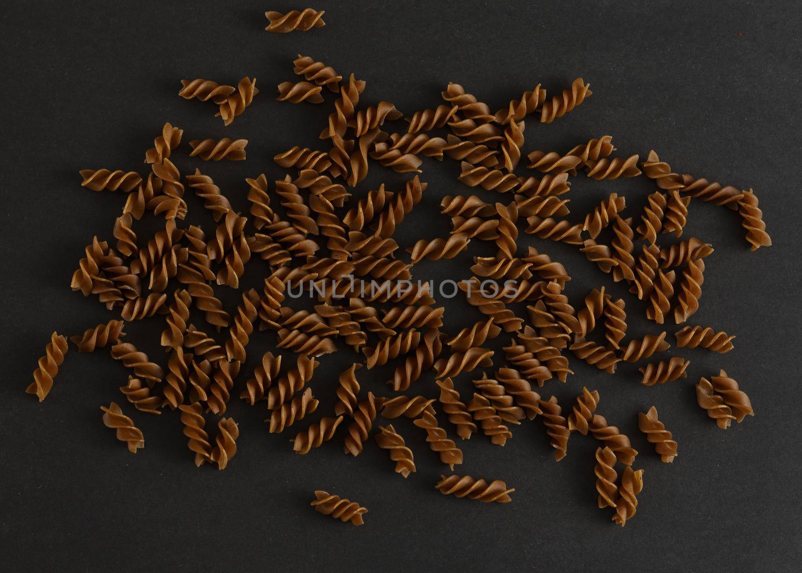 Flat lay with uncooked buckwheat pasta on black background. Concept of dieting, gluten free food, wellness and healthy lifestyle. High quality photo