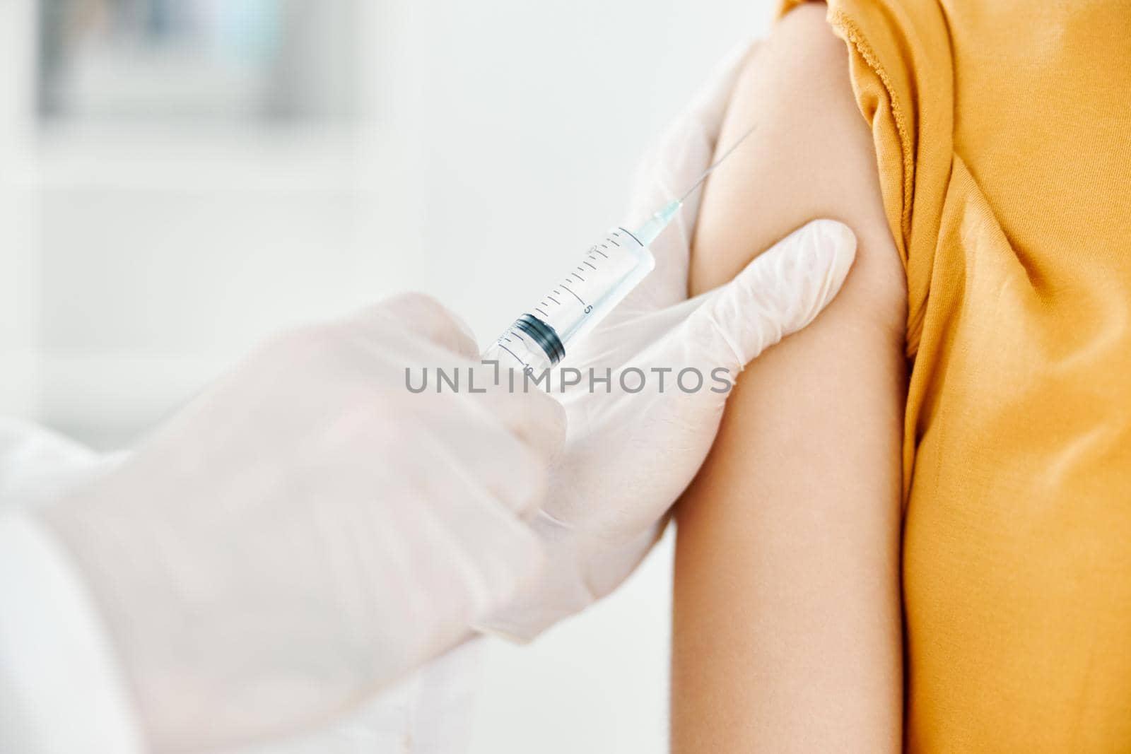 a doctor injects a covid-19 vaccine into a woman's shoulder. High quality photo