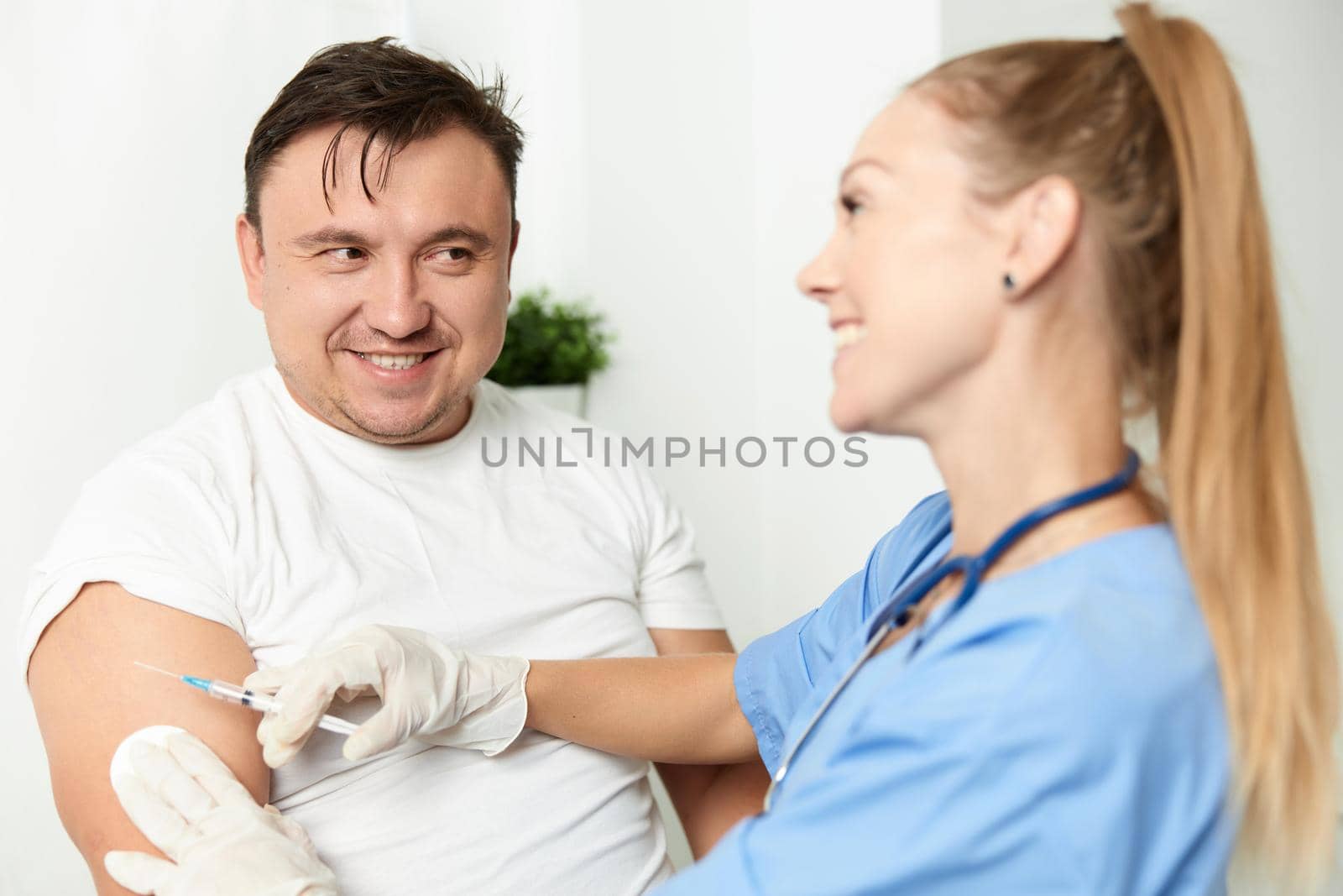 male patient next to doctor woman injection health covid vaccination by SHOTPRIME