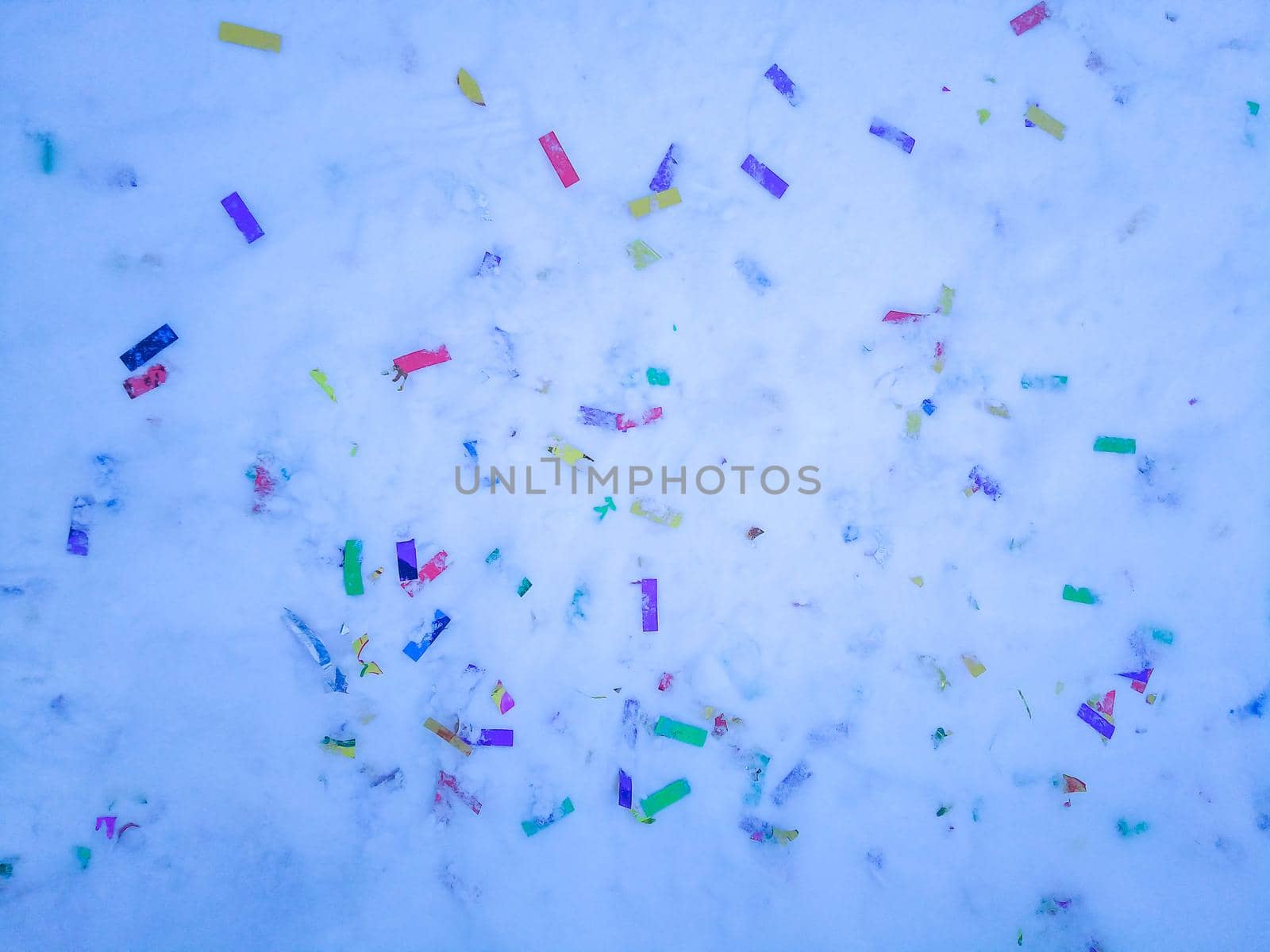 Colorful confetti glitter on the snow after holiday. No plastic, eco living concept.