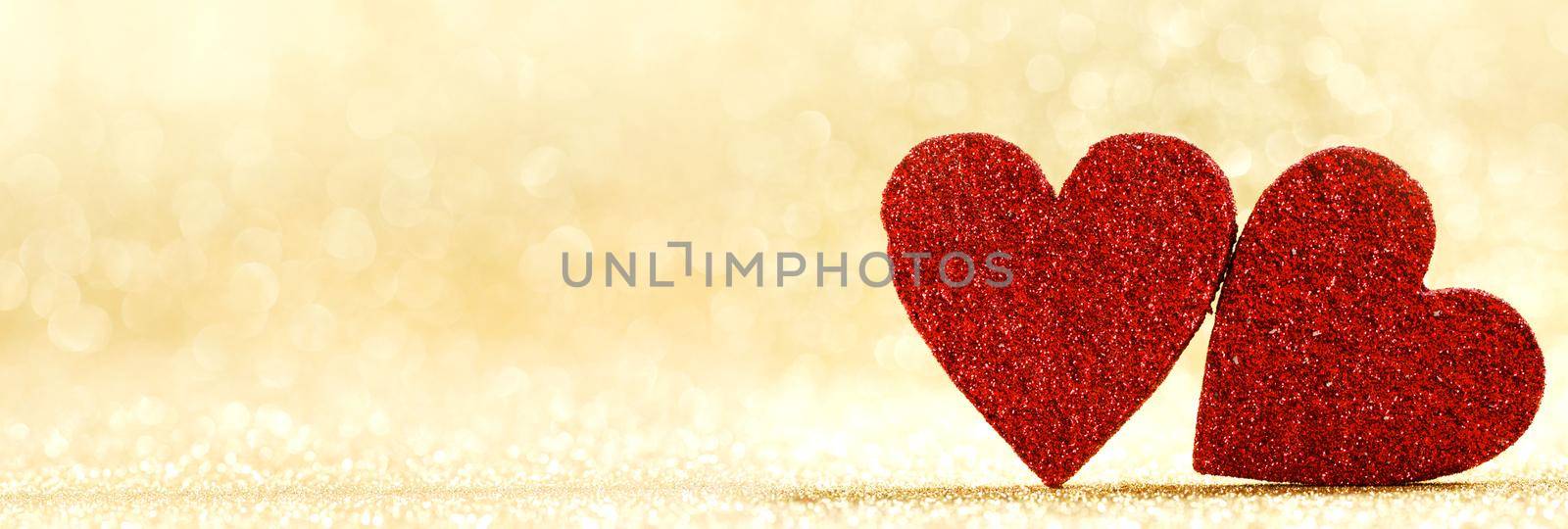 Two red hearts symbol of love on golden background with beautiful bokeh, Saint Valentine Day celebration, copy space for text