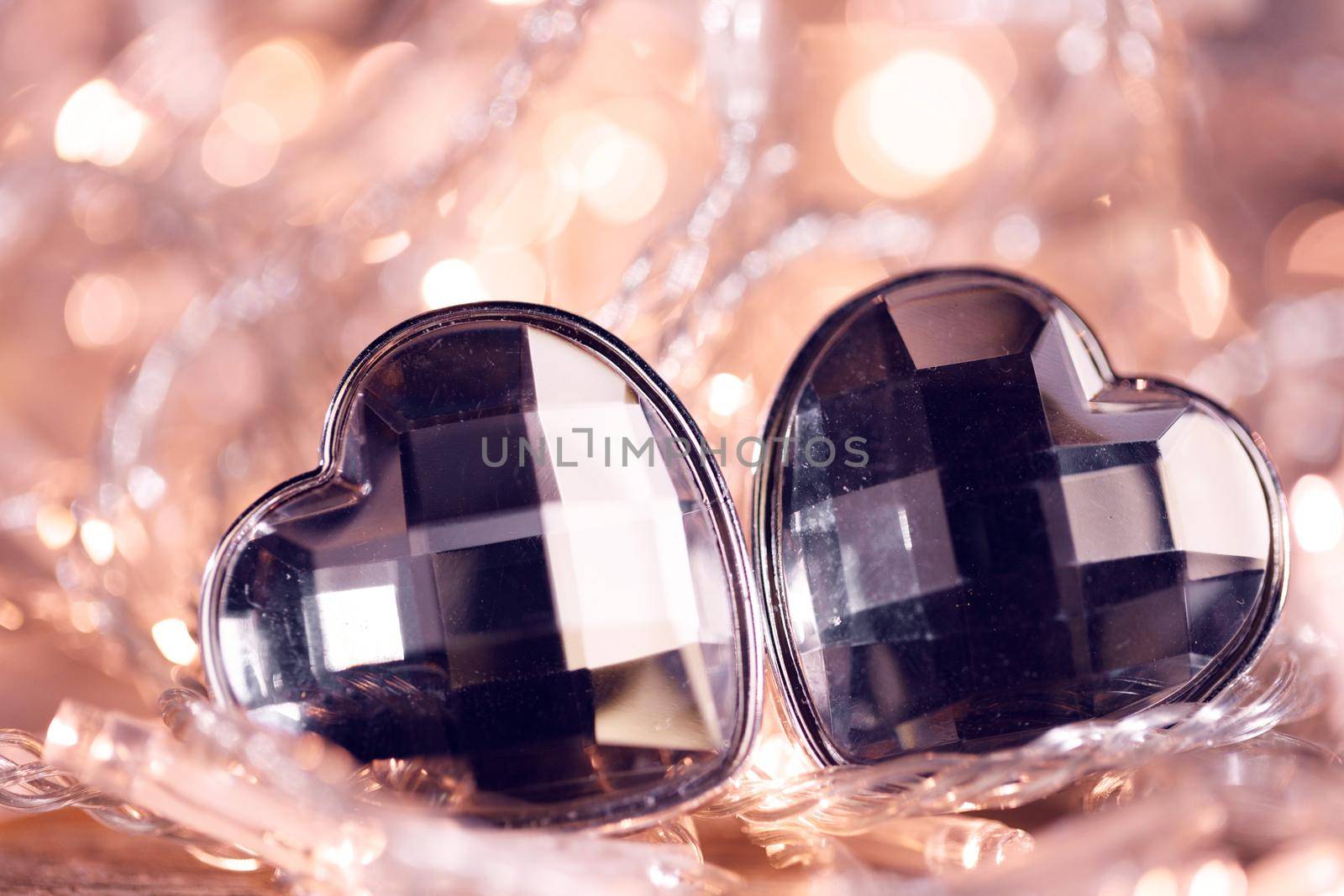 Heart shaped gem stones on golden lights of electric garland with bokeh