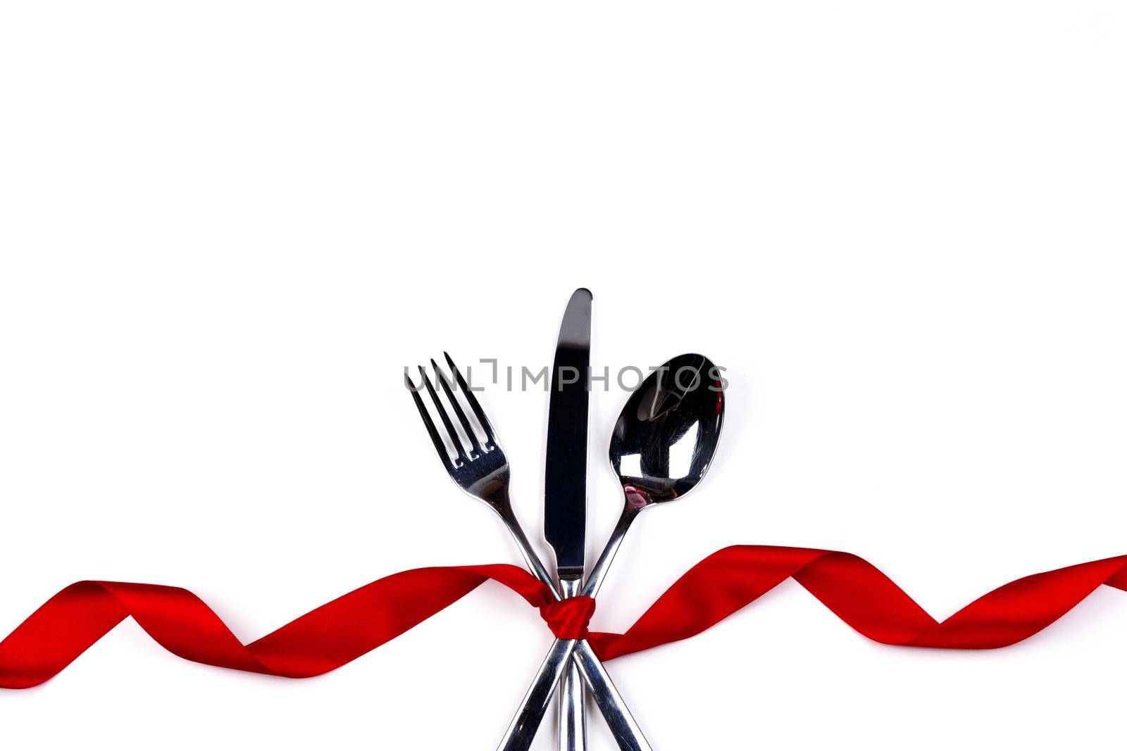 Fork, spoon and knife Cutlery set tied with silk ribbon isolated on white background
