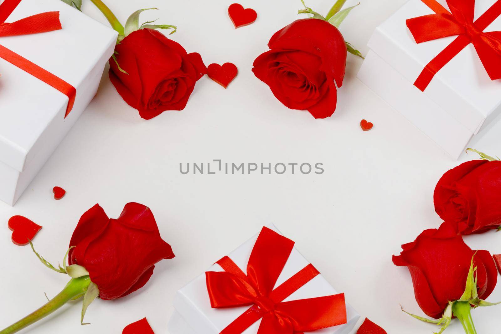 Red rose flowers gifts and red hearts composition on white background top view with copy space. Valentine's day, birthday, wedding, Mother's day concept. Copy space