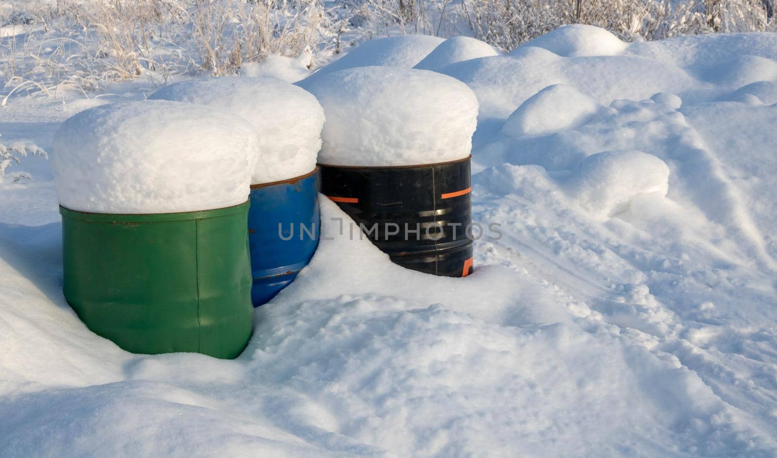 Frozen crumpled red barrel in the snow.