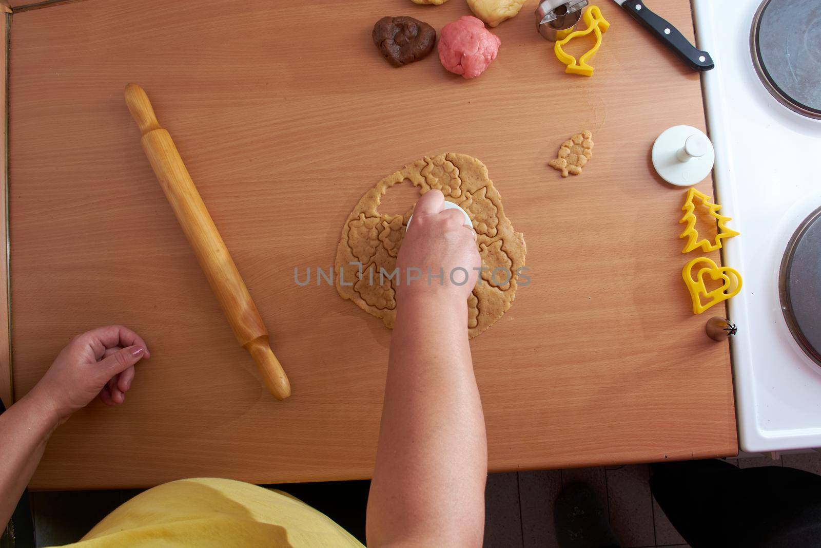 Cutting cookies from the dough and preparing for bake in the electrical stowe