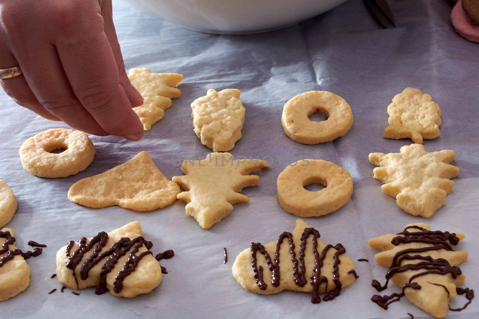 Pouring chocolate on just baked christmas cookies