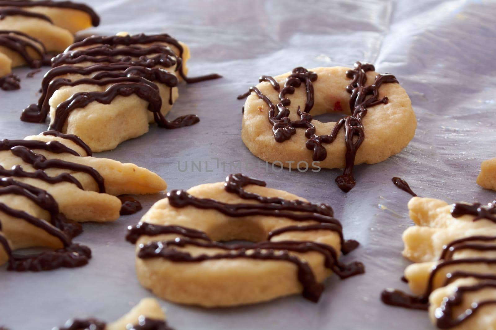 Pouring chocolate on just baked christmas cookies by radebg