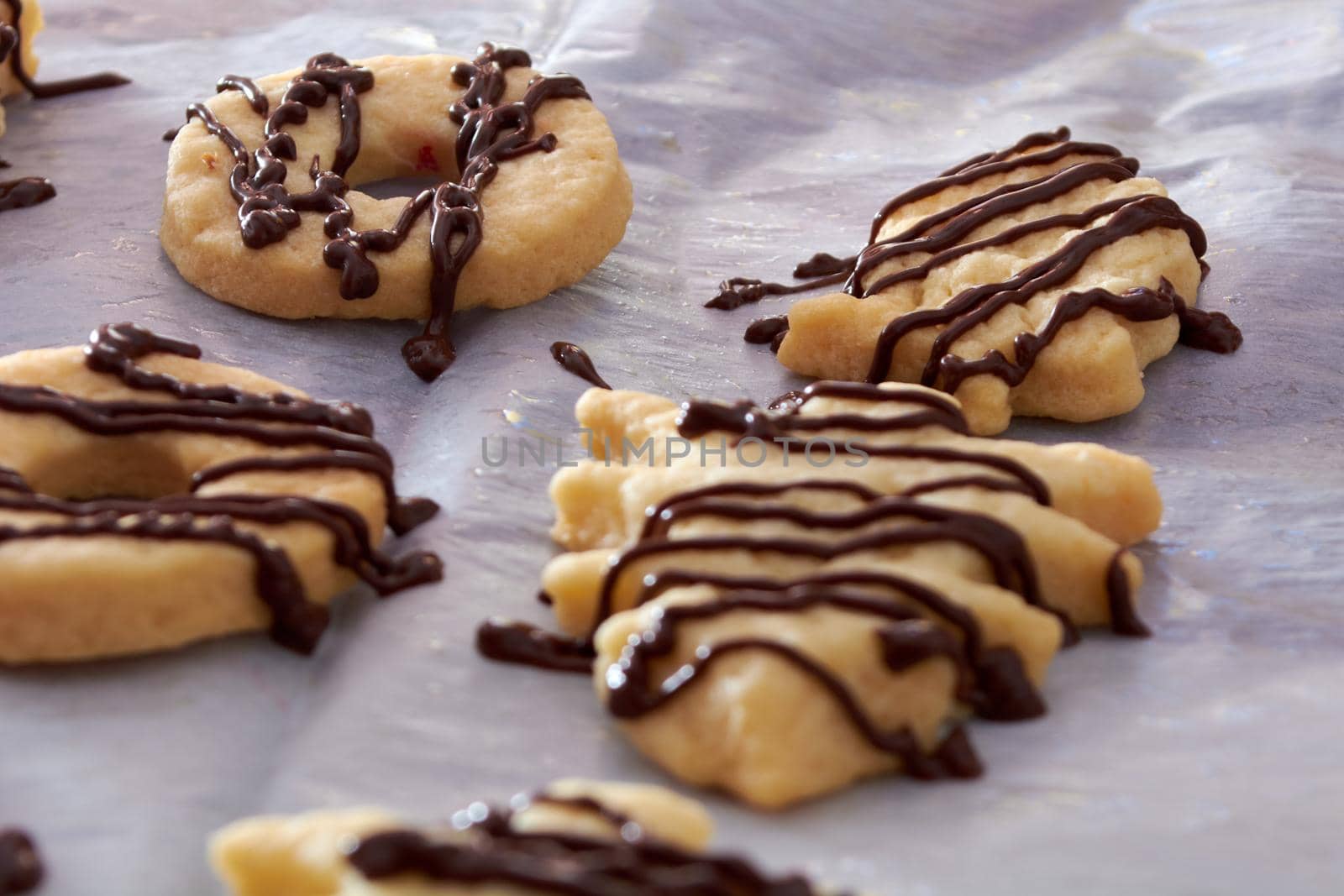 Pouring chocolate on just baked christmas cookies by radebg