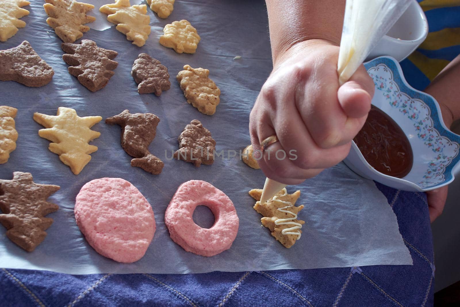 Pouring chocolate on just baked christmas cookies by radebg