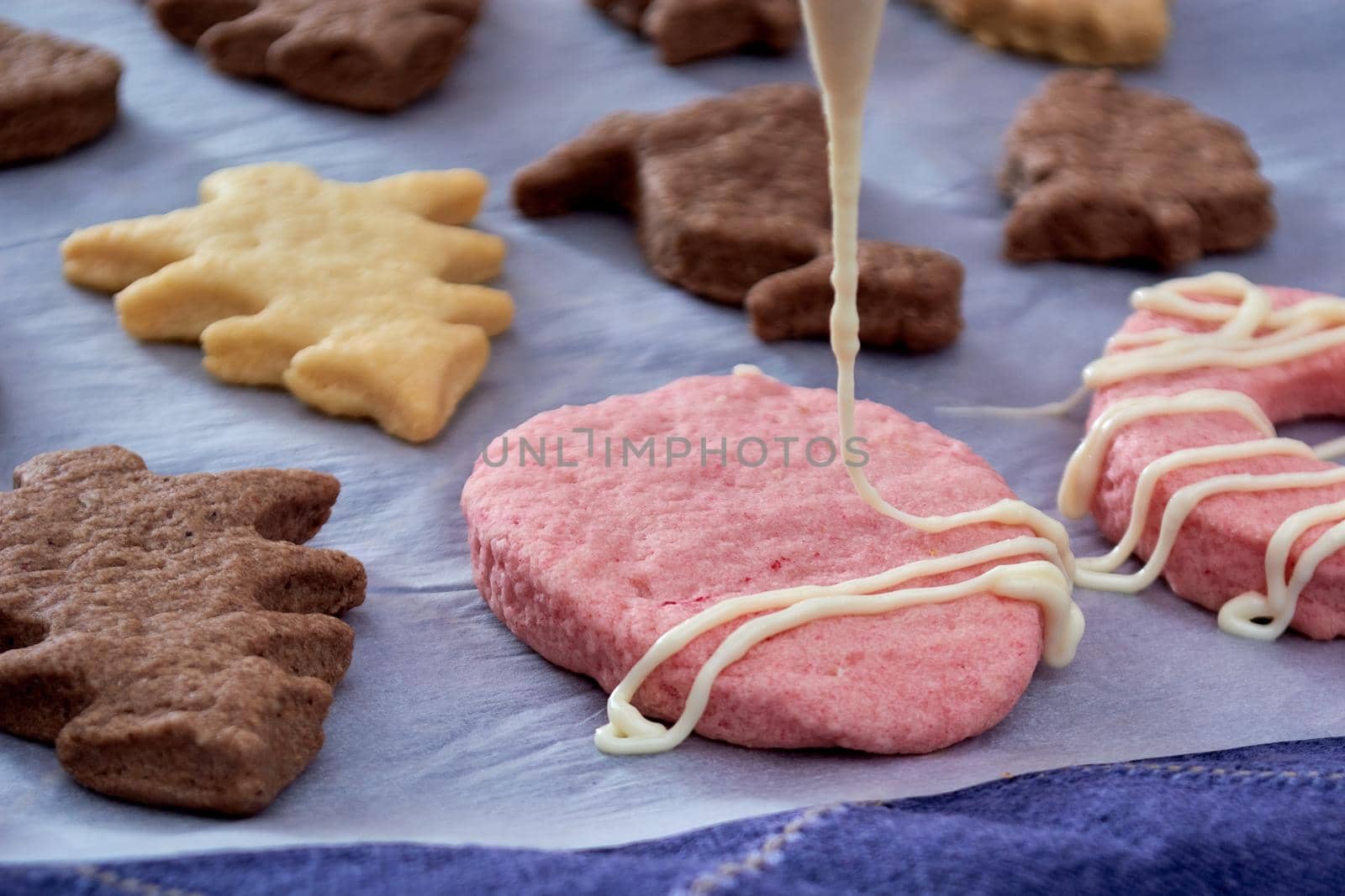 Pouring chocolate on just baked christmas cookies by radebg