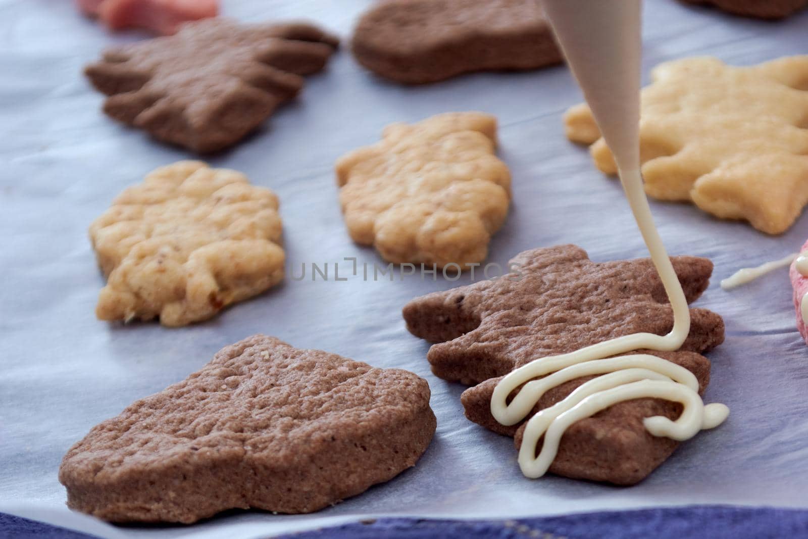 Pouring chocolate on just baked christmas cookies by radebg