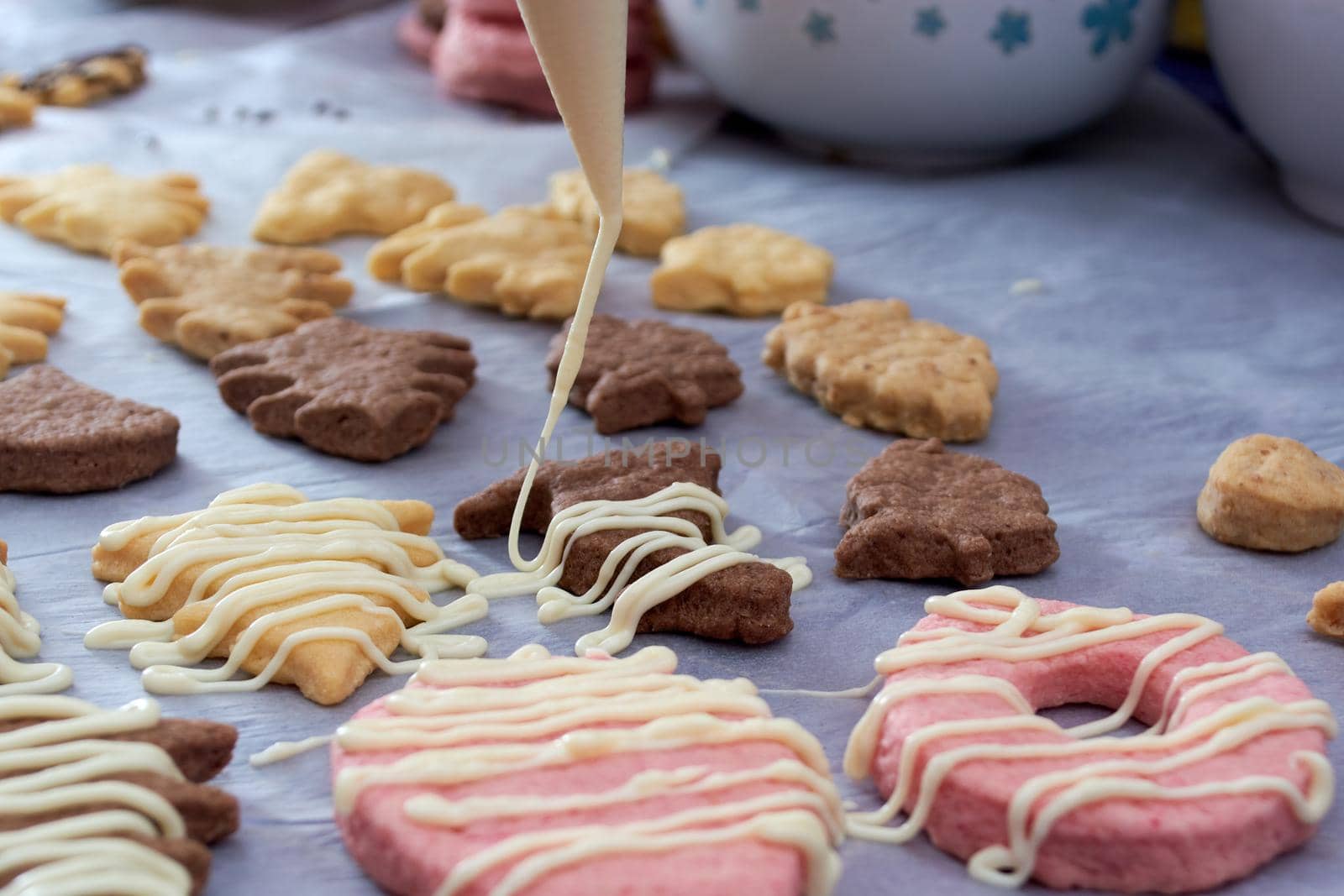 Pouring chocolate on just baked christmas cookies