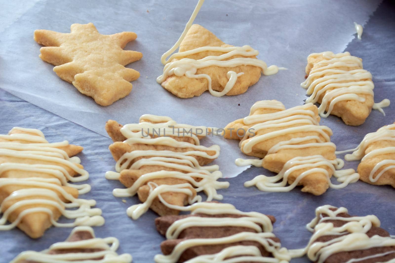 Pouring chocolate on just baked christmas cookies