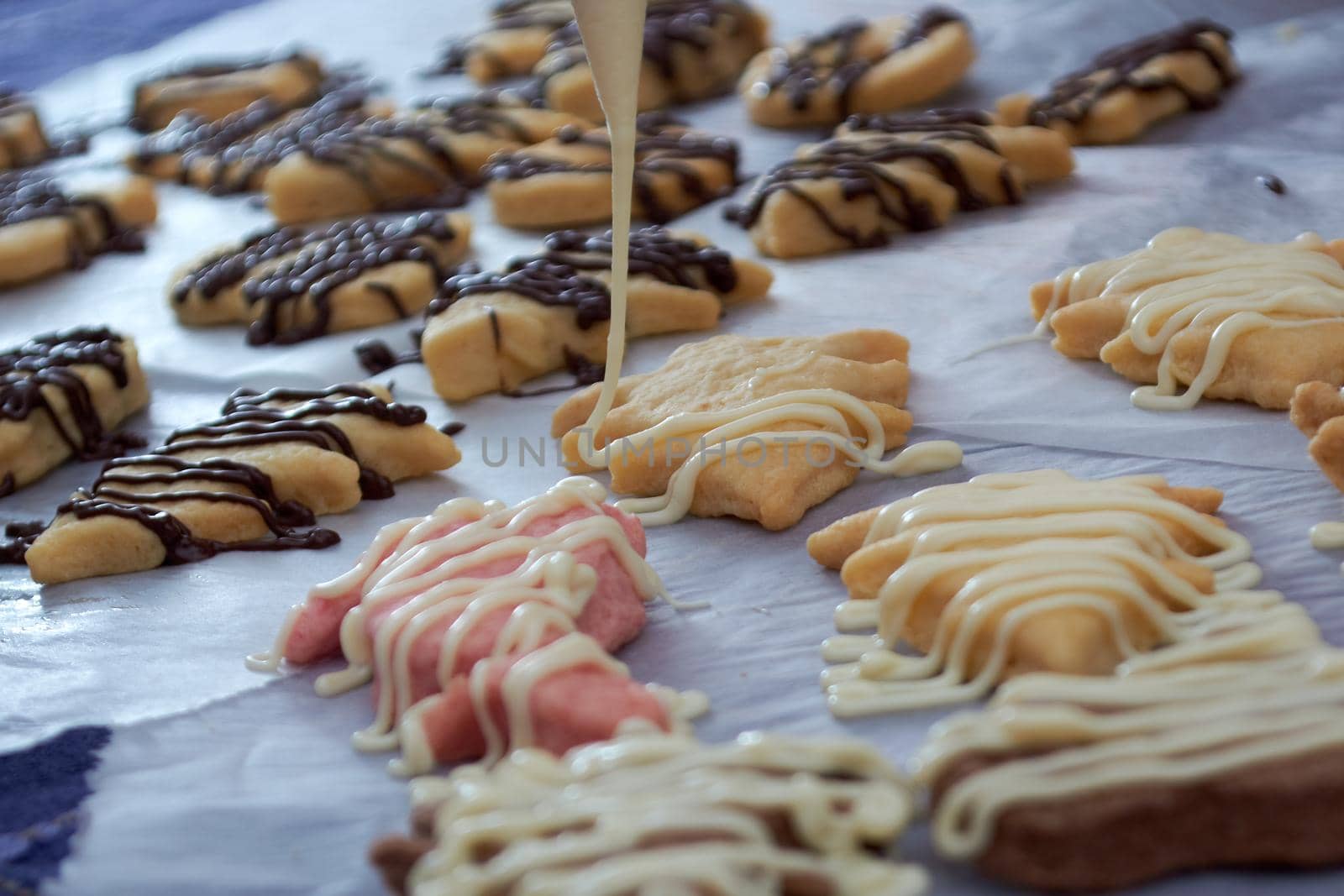 Pouring chocolate on just baked christmas cookies by radebg