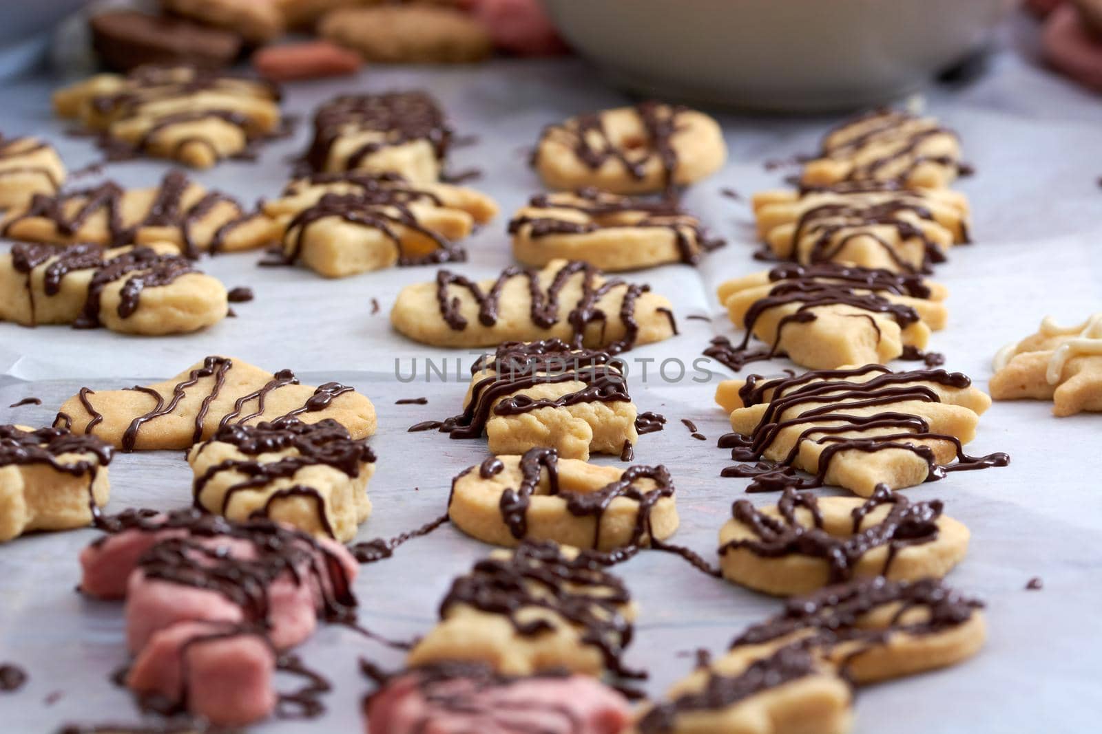 Pouring chocolate on just baked christmas cookies