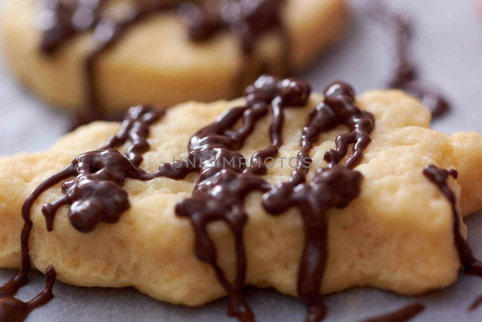 Pouring chocolate on just baked christmas cookies