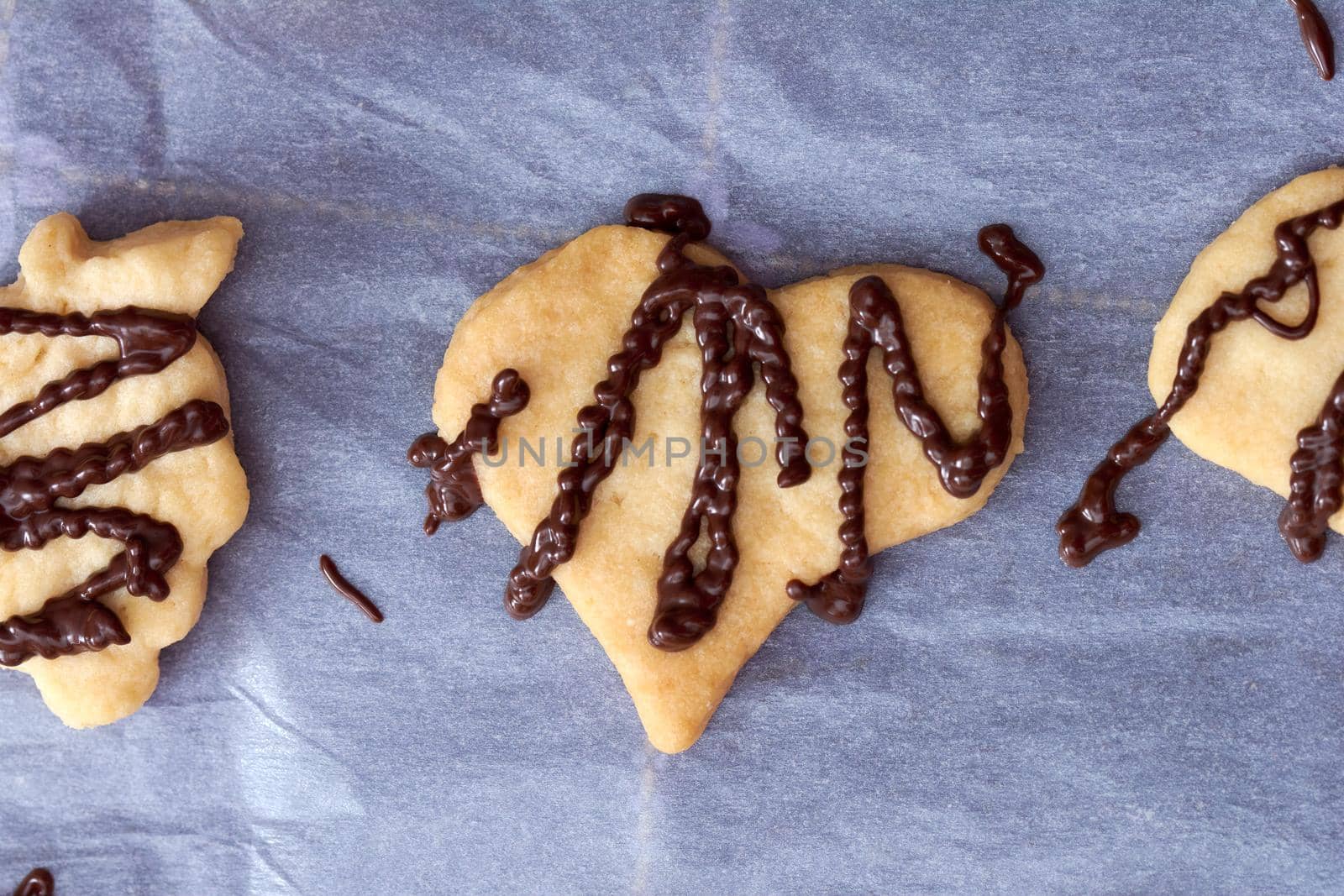 Pouring chocolate on just baked christmas cookies