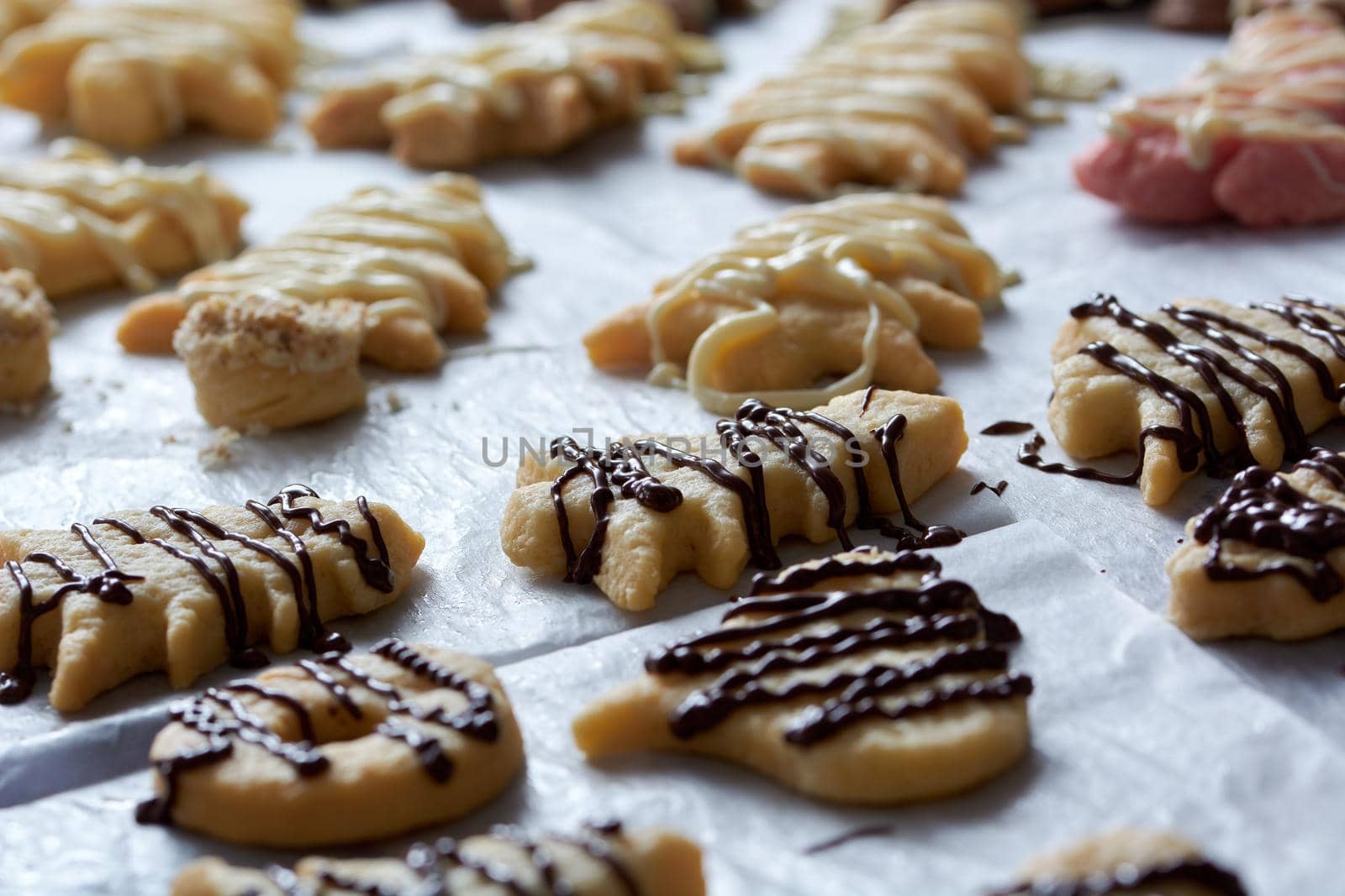 Pouring chocolate on just baked christmas cookies