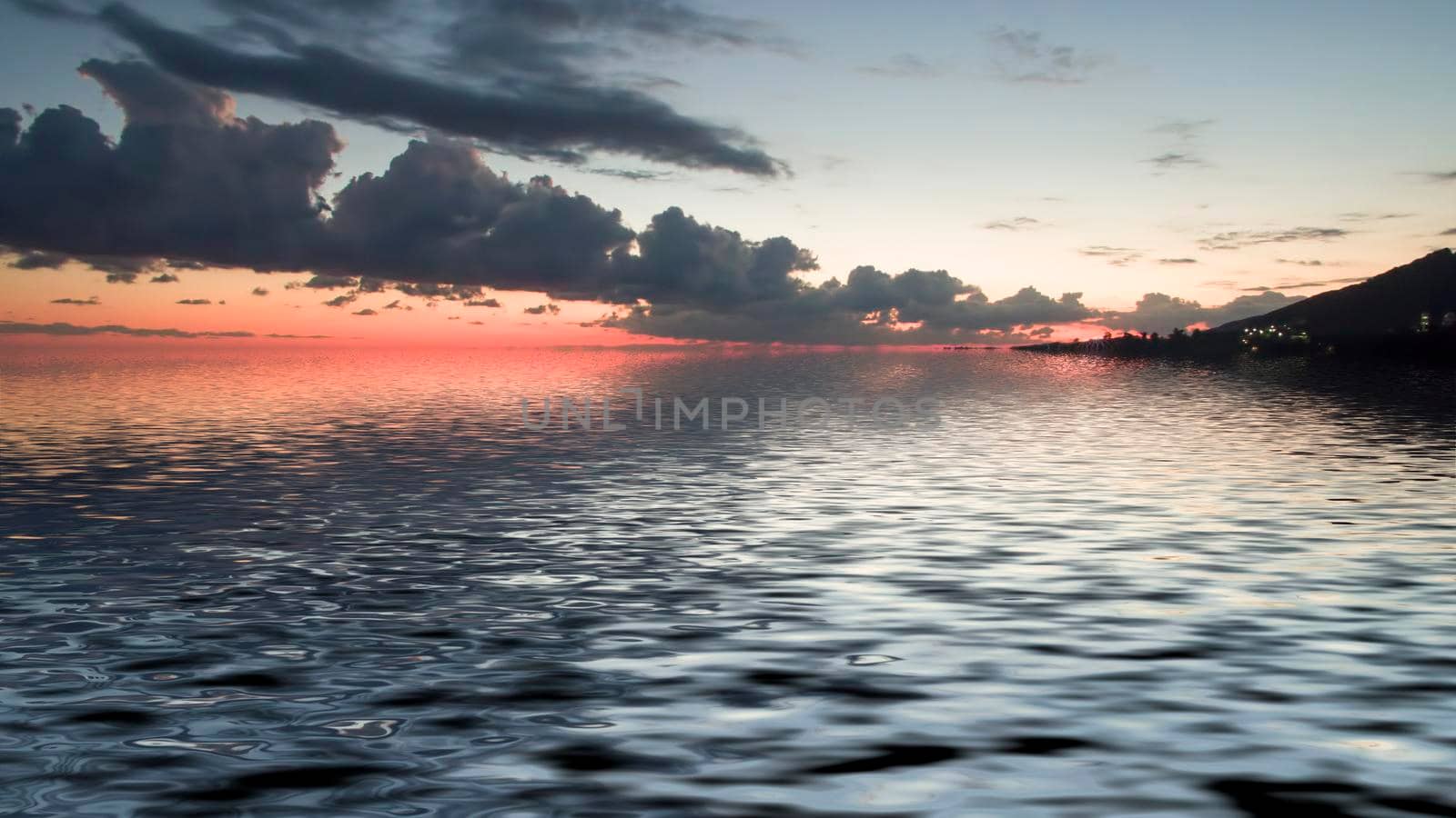 Sea landscape with dramatic sunset views and a large cloud.