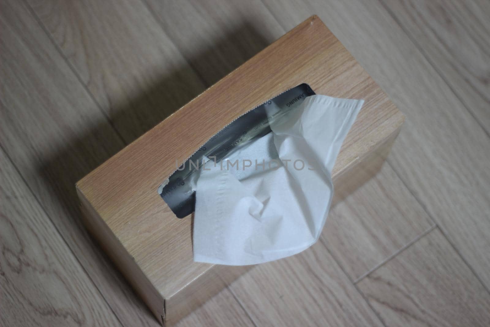 Tissue box on wooden table by Photochowk