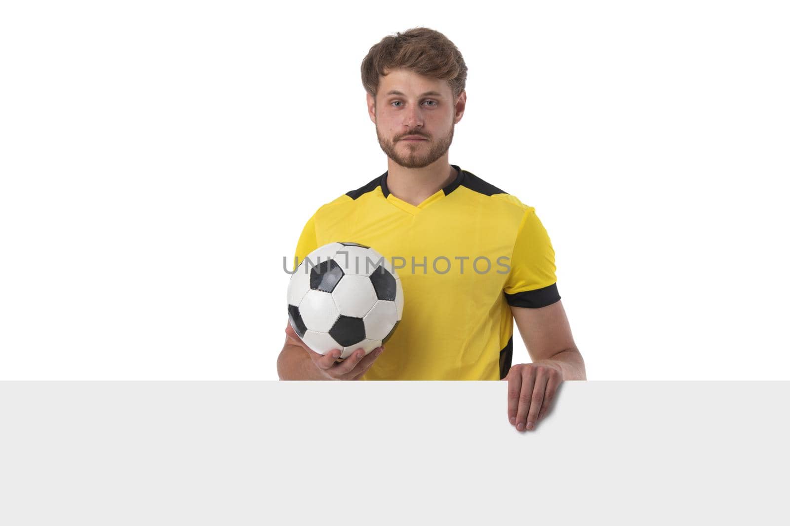 Portrait of young soccer player with football and billboard isolated on white background