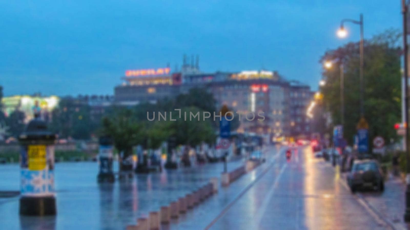 Blurred background. Evening city landscape, city street with lights and passers-by. Creative story for a background, poster, banner, or screensaver.