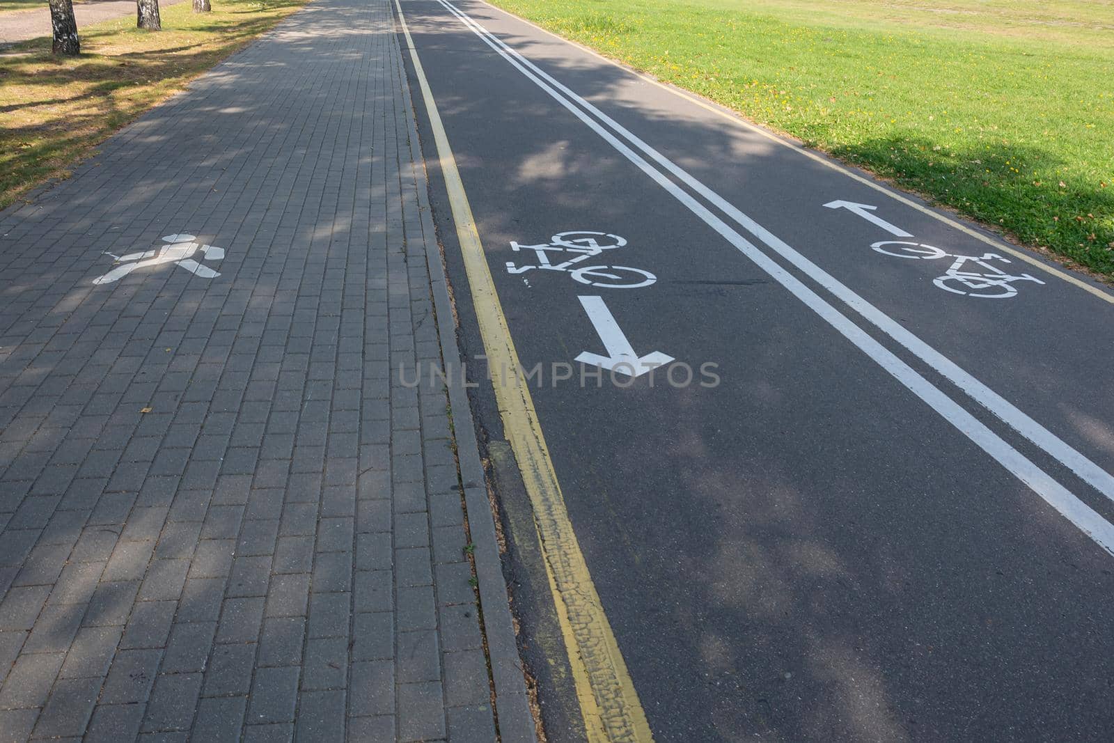 bike path with a Bicycle sign and a sidewalk with a pedestrian sign. Stock photo.