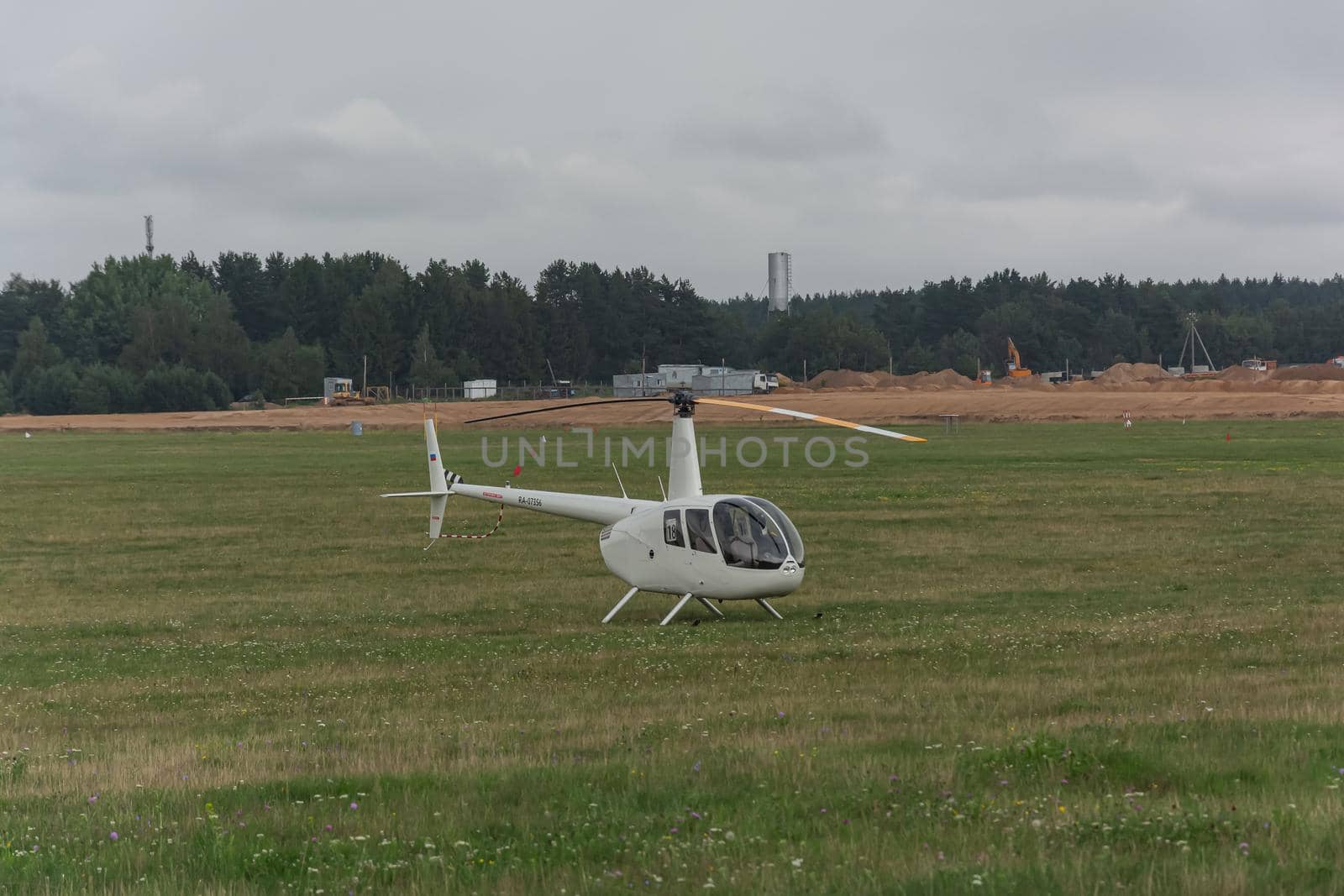 Minsk, Belarus - 07/25/2018: Helicopter on the green lawn of the airfield by Grommik