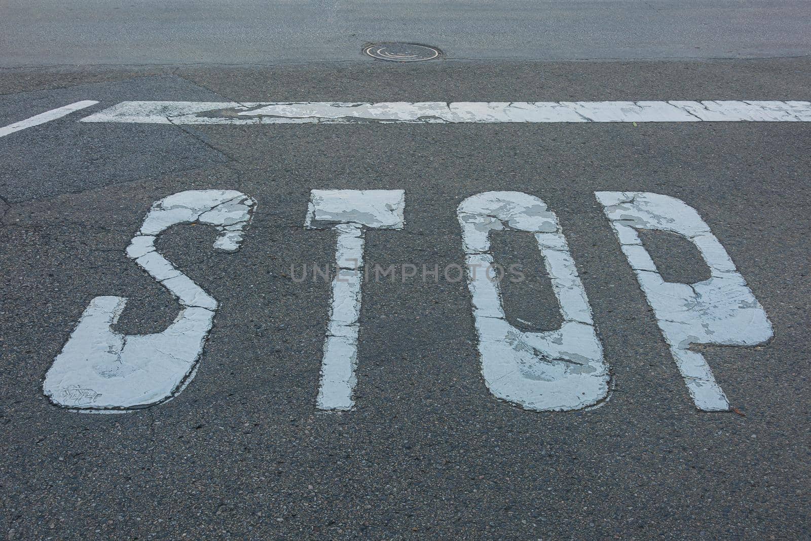 STOP sign and stop line are marked on the asphalt of the roadway by Grommik