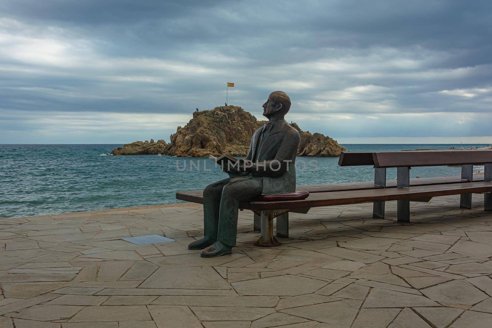 Spain, Blanes-09/14/2017: Monument to a man with a book on the background of a seascape. by Grommik