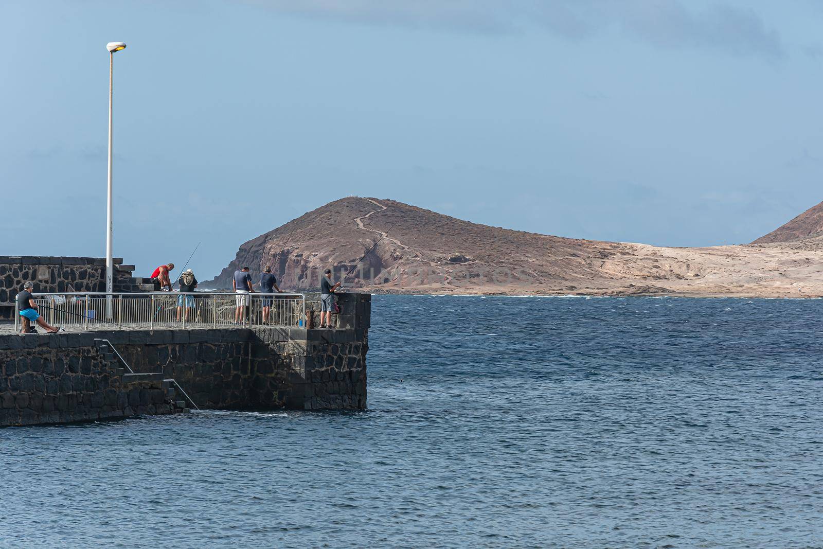 Fishermen on the sea pier catch fish. Stock photography
