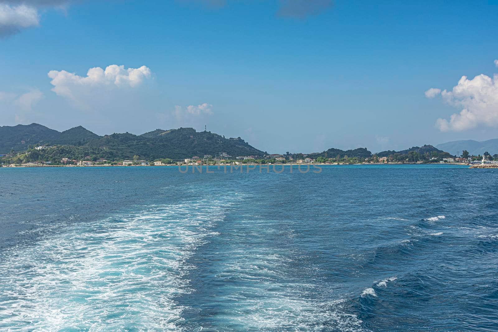 Seascape. Trail on the sea from the boat on the background of the coastline. Stock photo