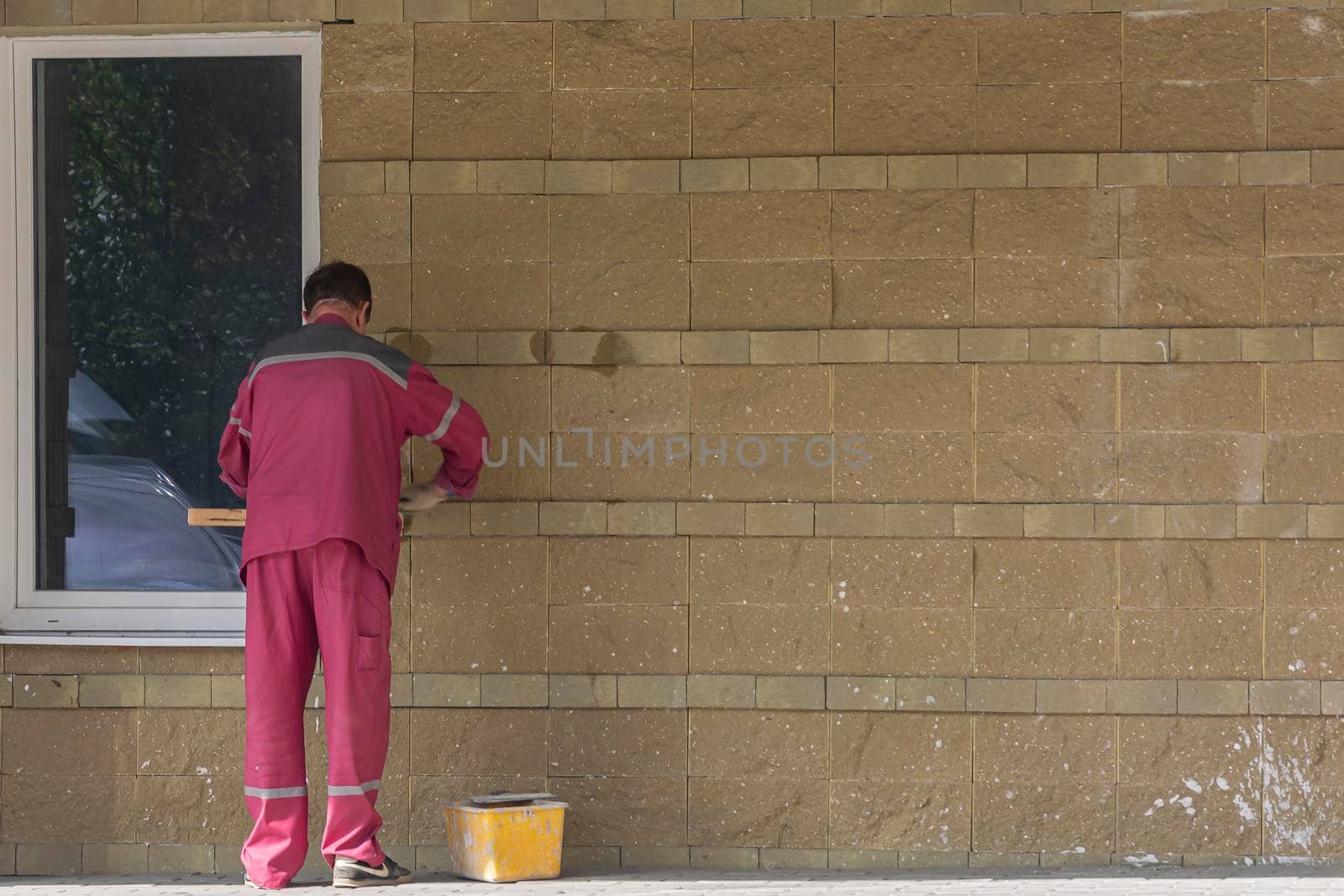 Russia, Bryansk-07/23/2018: a worker plasters the wall of a building. Stock photo.