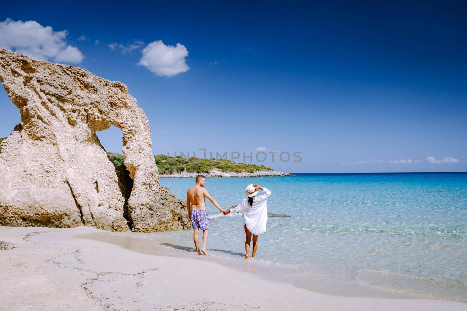 Young happy couple on seashore Crete Greece, men, and woman Voulisma beach Crete Greece. Europe